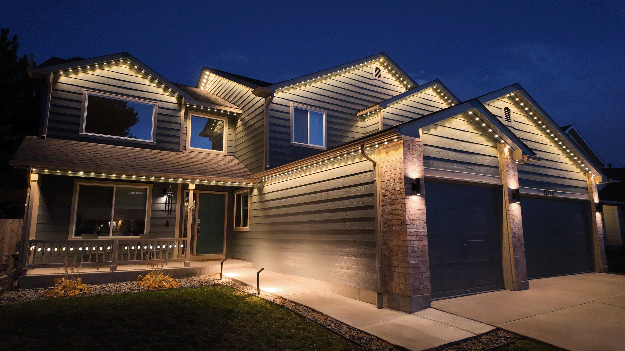 Bluffton home illuminated by warm-white permanent under-eave roofline lights at night